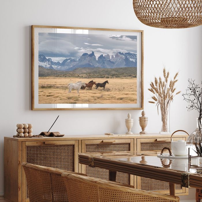 A framed photograph of horses in a field, hanging on a dining room wall, enhancing the modern rustic decor