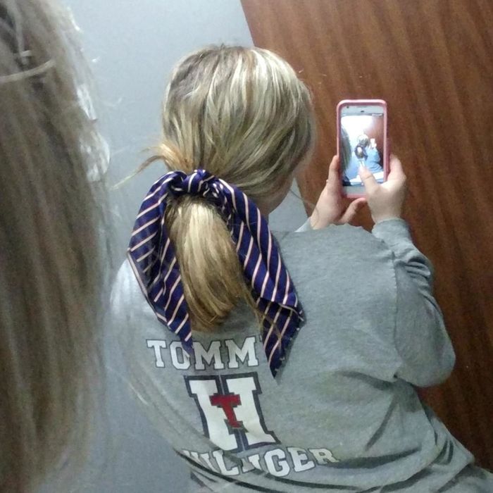 A reviewer showing off their hair styled with the navy striped scrunchie that features long, flowing ends
