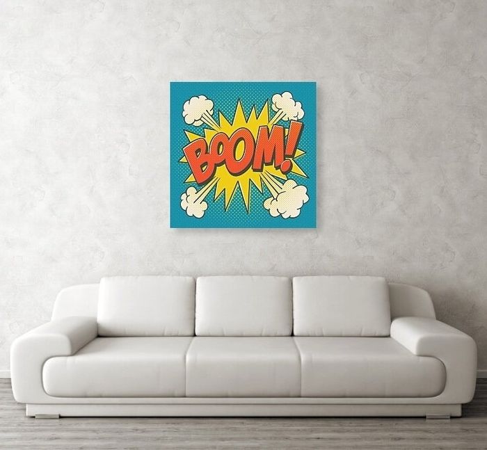 A pop art-style 'BOOM!' poster displayed above a white sofa in a minimalist living room, ideal for modern home decor