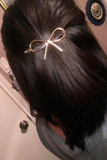 A reviewer showcasing the gold bow clip