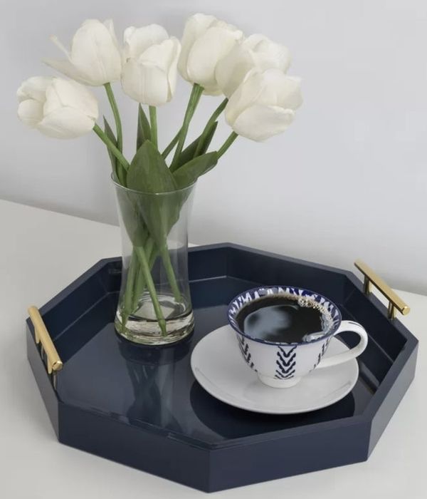 A tray holding a vase of white tulips and a coffee cup