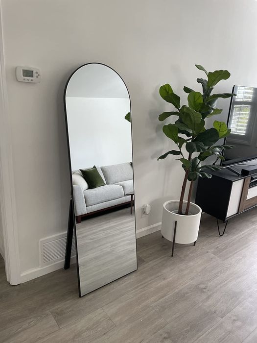 A reviewer's floor mirror is pictured leaning against a living room wall