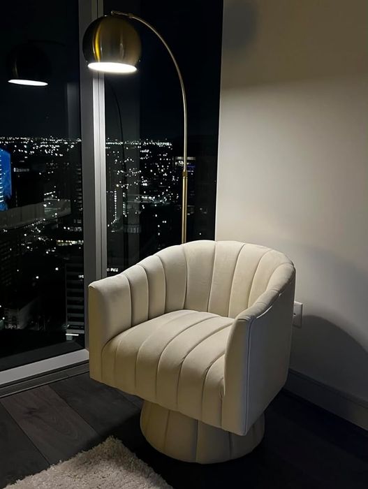 A modern chair placed in a room with a stunning view of the city skyline, perfect for adding a chic touch to any home decor theme