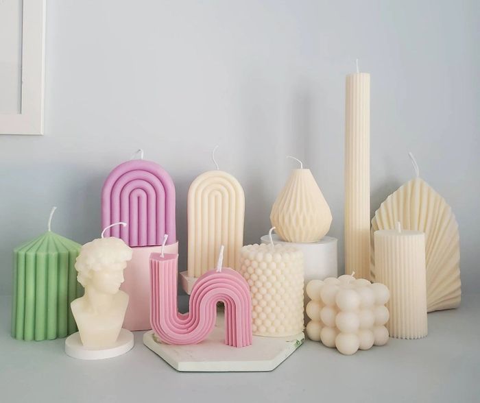 A collection of candles in various shapes and designs is displayed