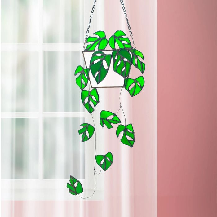 A green stained glass artwork shaped like a plant is displayed