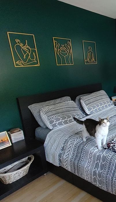 A reviewer's bedroom features a green wall adorned with three pieces of the wall art