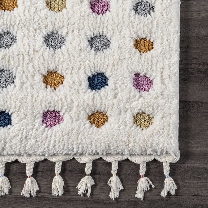 A close-up of the polka dot rug with tassels, showcasing the vibrant details.