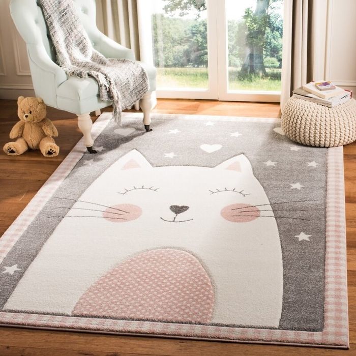 A gray rug with a cat design placed in a child's room.