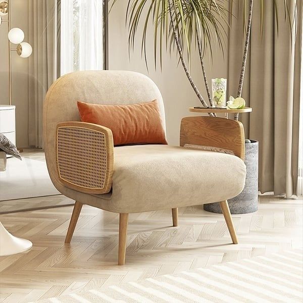 A modern armchair with a beige upholstered seat, wood backrest, and cane side panels, set in a stylish interior