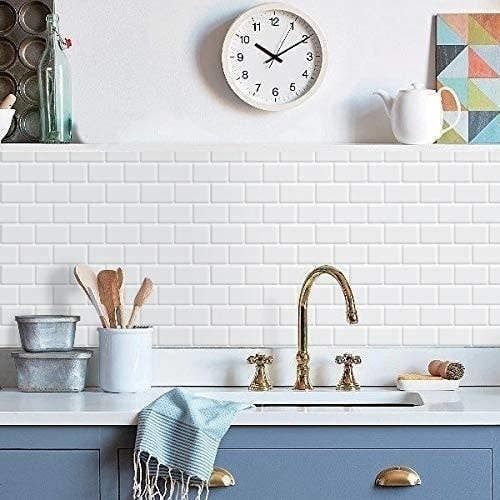 White tiles installed on a wall behind a sink