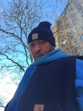 reviewer photo of a person wearing a Carhartt navy cap paired with a matching coat