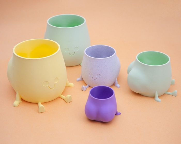 yellow, green, and purple booty planters with smiley faces