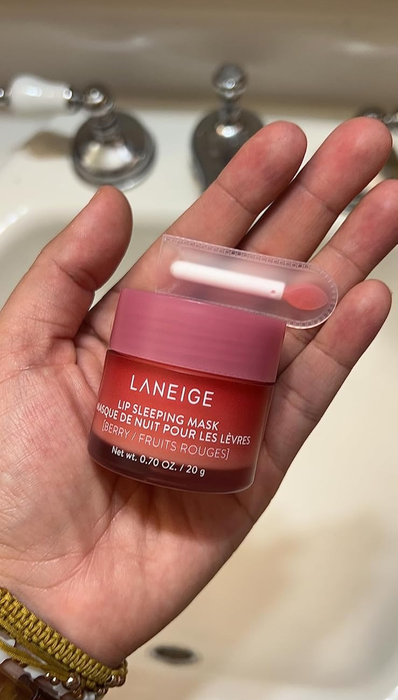 A reviewer showcases the Laneige Lip Sleeping Mask, Berry (0.70 oz/ 20g), holding the jar in front of a sink.