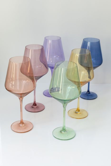 A set of six stemware glasses in soft pastel shades, arranged in two neat rows for a charming display