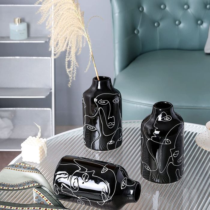Three black vases with abstract phrases intricately etched into them