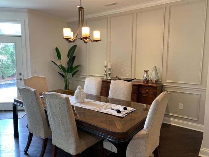 A reviewer's faux bird of paradise plant is pictured in the corner of a dining area