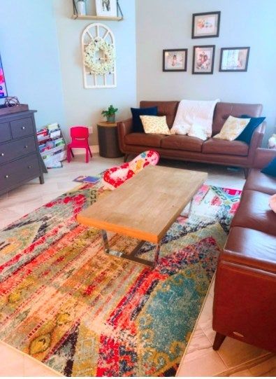 A bright, colorful rug under a coffee table in a reviewer's living room