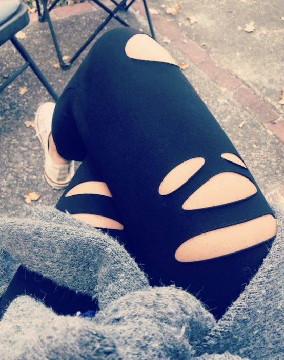 reviewer wearing leggings with cutouts, paired with a cozy sweater