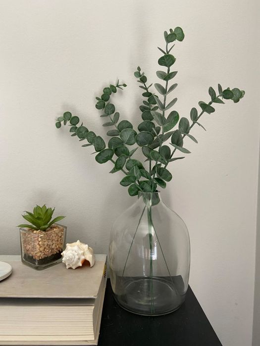 A reviewer's faux eucalyptus stems are displayed in a vase