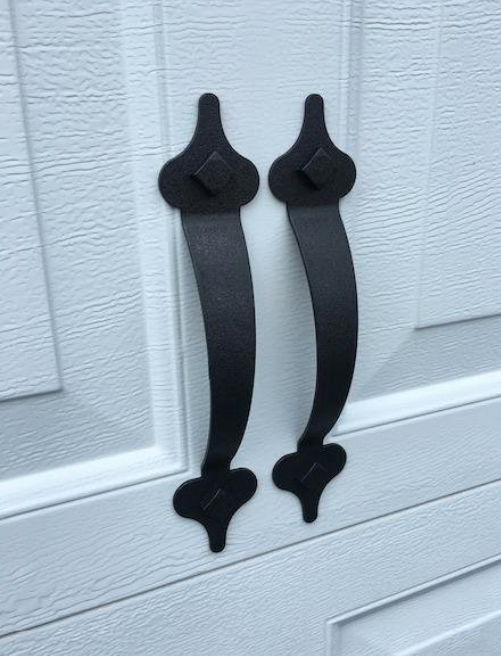 Close-up image of garage handles, designed to resemble iron with riveted detailing