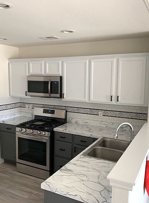 After: The top cabinets are painted white, while the bottom ones are in a grey finish.