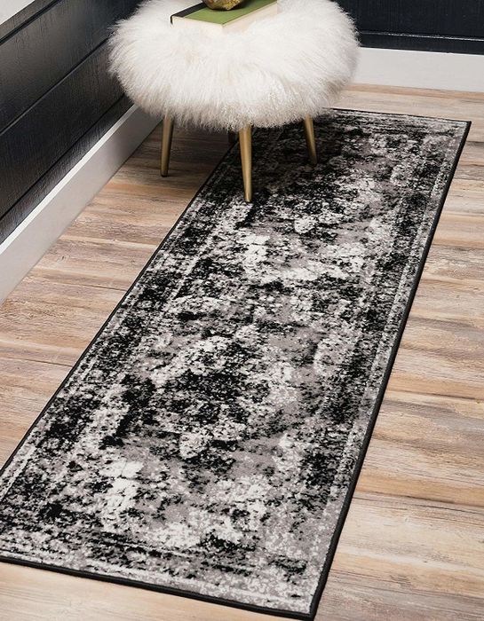 A black, gray, and white rug runner with an antique-inspired design.