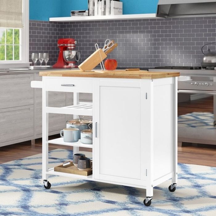 A white kitchen island cart with wheels, shelves, and ample storage space.