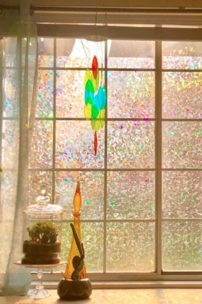 Light shines through the reviewer’s window, where a translucent rainbow film creates a soft, colorful shine across the glass.