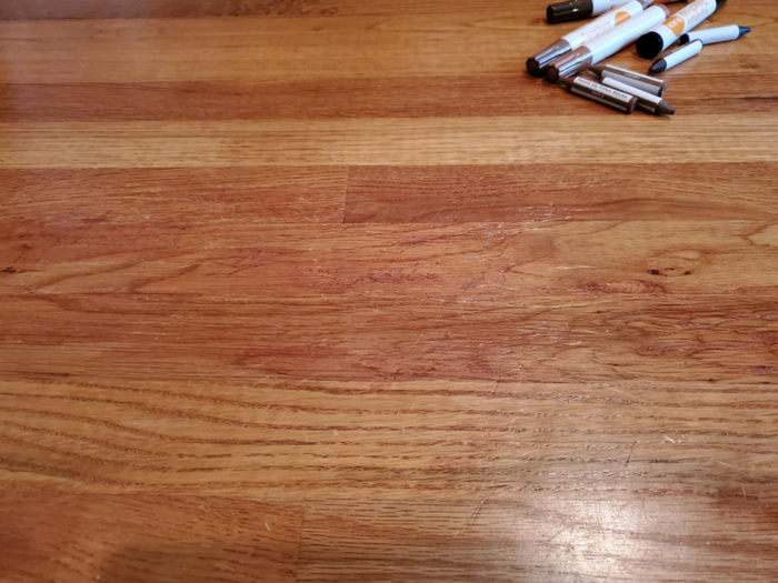 The same hardwood floor after restoration, now free of visible scratches unless you inspect it up close.
