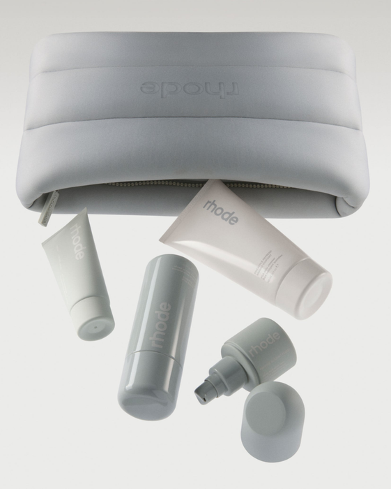 Cosmetics bag featuring skincare products from the brand Rhode, packed for travel.