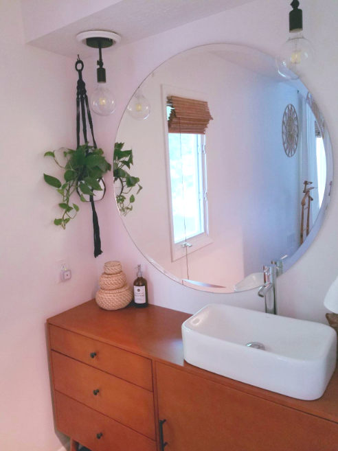 A bathroom featuring two pendant lights in place of the original can lights