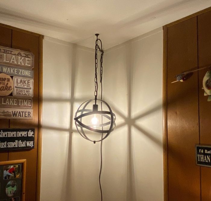 The light fixture is suspended in the corner of a reviewer's home, adding a unique touch to the space.