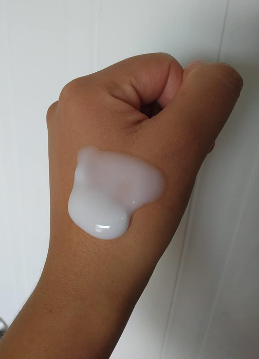 A reviewer with a white cleanser on their hand.