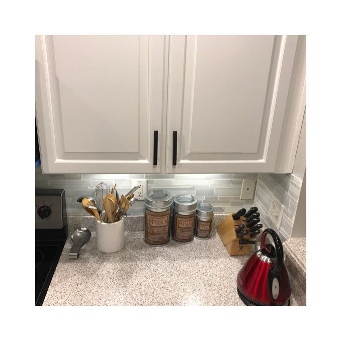 A reviewer's kitchen with both the under-cabinet lights and the main kitchen lights turned on, brightening the space.