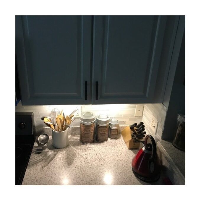A reviewer's kitchen cabinets, lit only by under-cabinet lights, which highlight the display beneath.