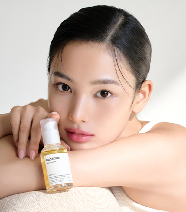 A woman models a skincare product while gazing at the camera, featured in a shopping article.