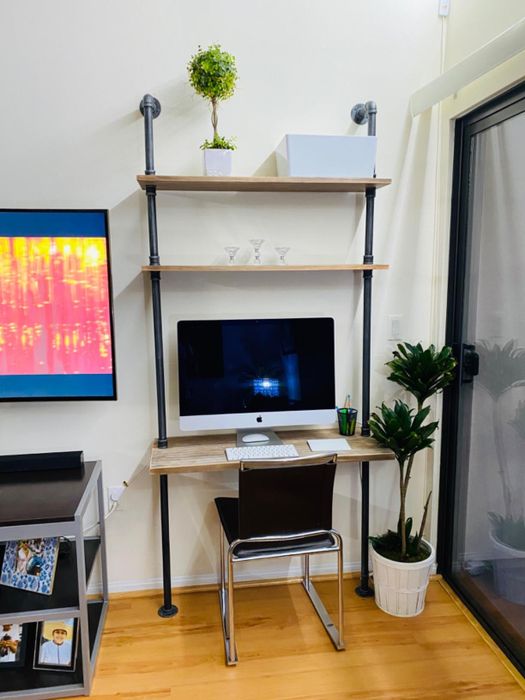 A reviewer's wall-mounted desk supporting an iMac computer
