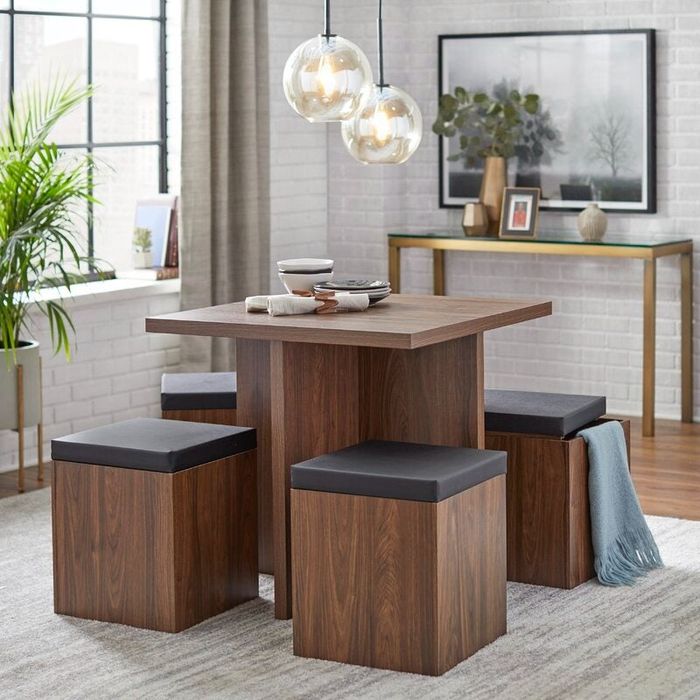 A five-piece brown dining set featuring a table and four stools, with one stool that opens to reveal hidden storage and a blanket inside.