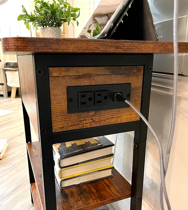 The side of the same table, showing built-in outlets and USB ports for convenient charging functionality.