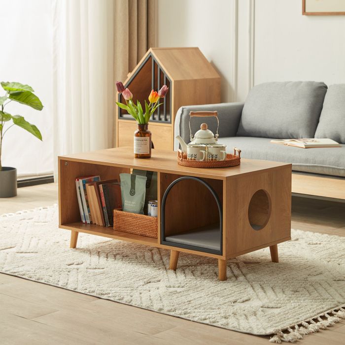 A wooden coffee table featuring a pet bed area, two openings for pets to access, and an additional cubby for storage.