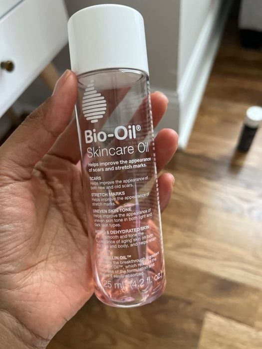 A reviewer holding a bottle of Bio-Oil.