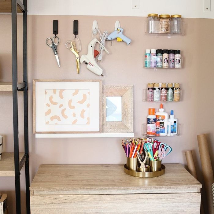 A craft area with a white ledge shelf showcasing two framed pieces of art.