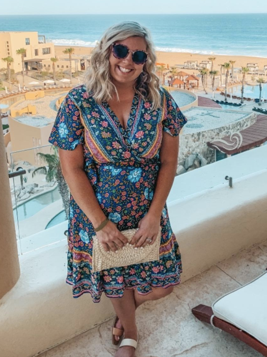 A reviewer styling a multi-colored floral dress
