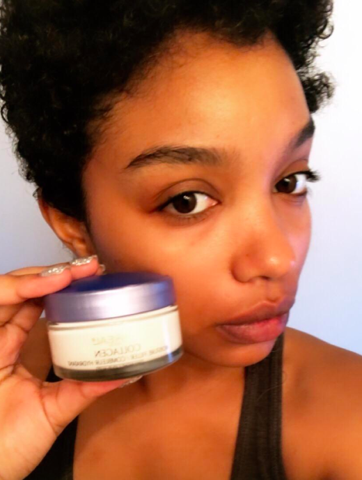 A reviewer’s selfie featuring them holding a container of moisturizer