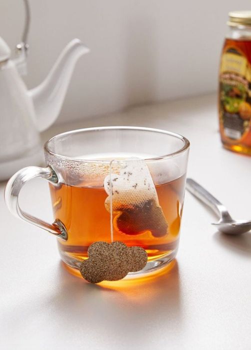 a tea glass featuring a tea bag shaped like a cloud