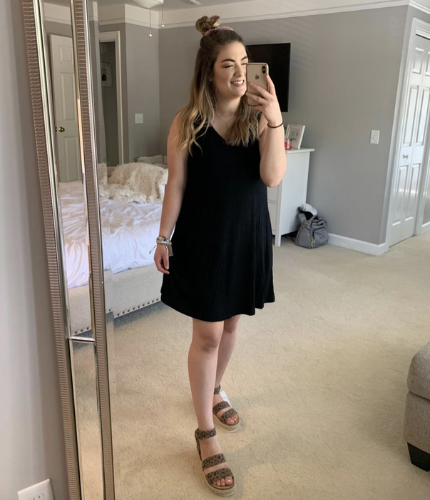 A customer wearing a black sleeveless dress