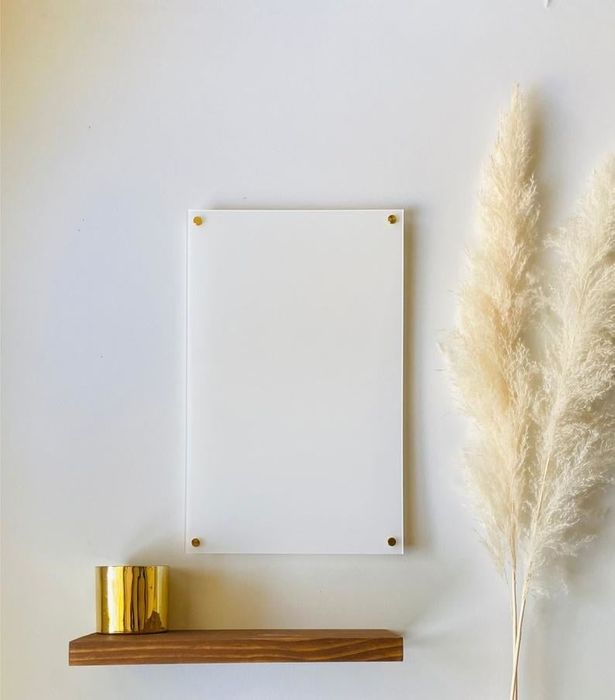 A sleek acrylic dry erase board mounted on the wall, ready for use.