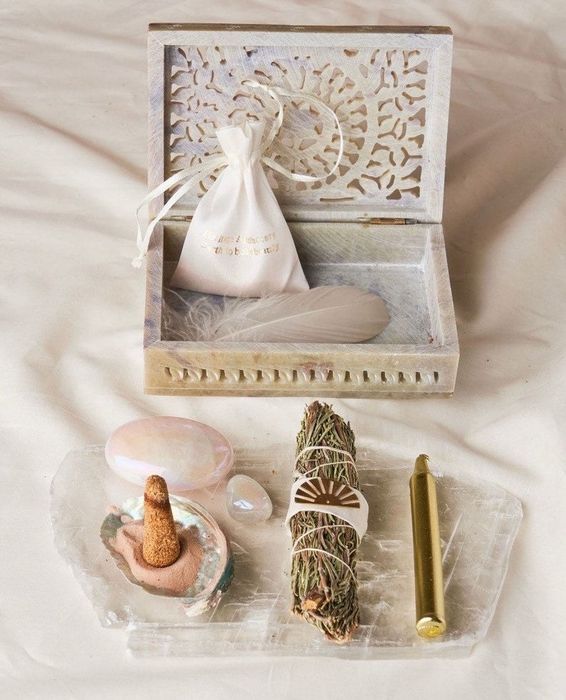 The Surrender Kit, featuring crystals, feathers, sand, incense, and additional items