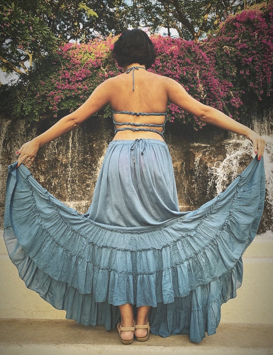 A customer wearing a light blue dress with three delicate straps on the back