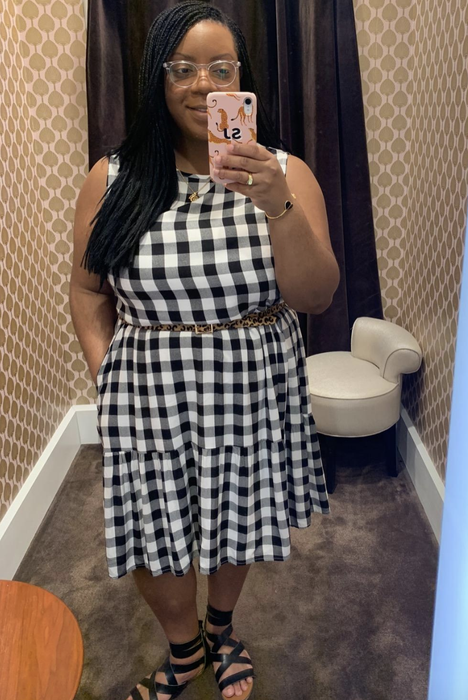 A reviewer in a dress accessorized with a belt